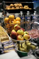 Un bufé con diversos alimentos, entre ellos frutas, pasteles y sándwiches.