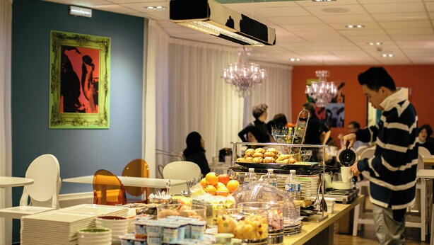 A buffet setup with various food items and a person serving. - Hôtel Gabriel (Le Mont-Saint-Michel)