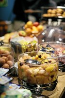 Un bufé con diferentes opciones de comida, incluyendo frutas, nueces y otros bocadillos.