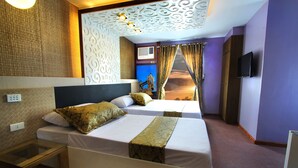 A hotel room with two beds, a TV, an air conditioning unit, and a decorative wall panel.