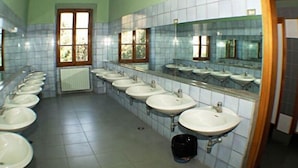 Een openbaar toilet met meerdere wasbakken en spiegels.