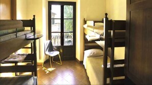 Een kamer met stapelbedden, een stoel en een raam met uitzicht.