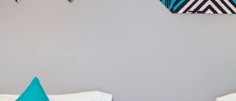 A hotel room with a bed, a nightstand with a phone, and decorative wall art.