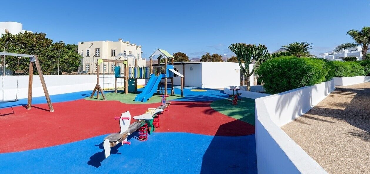 A playground with a slide, swings, and a climbing structure.