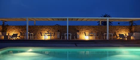 Una piscina al aire libre de temporada, sombrillas