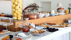 A buffet with various food items including fruits, pastries, and condiments. - Ammos Hotel (Skiros)
