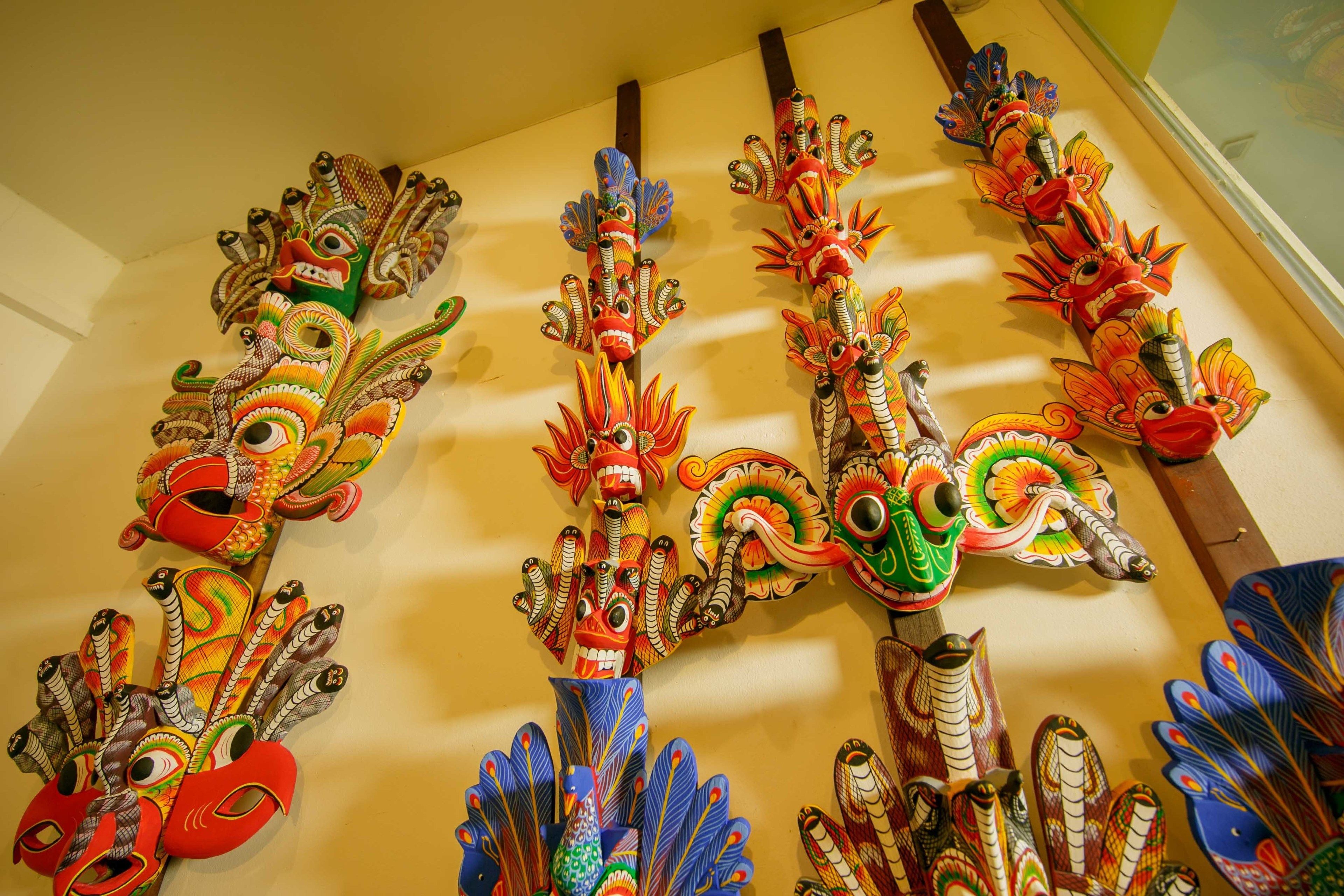 A collection of colorful, intricately designed masks hanging on a wall.