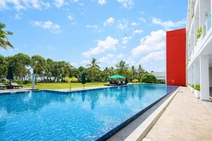 Una piscina al aire libre, sombrillas, tumbonas