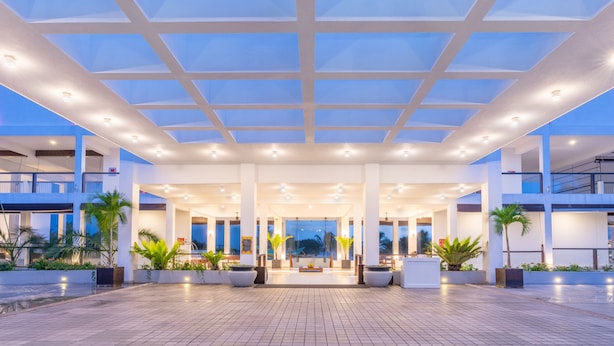A modern hotel lobby with a spacious open area, large windows, and potted plants. - Citrus Waskaduwa (Wadduwa)