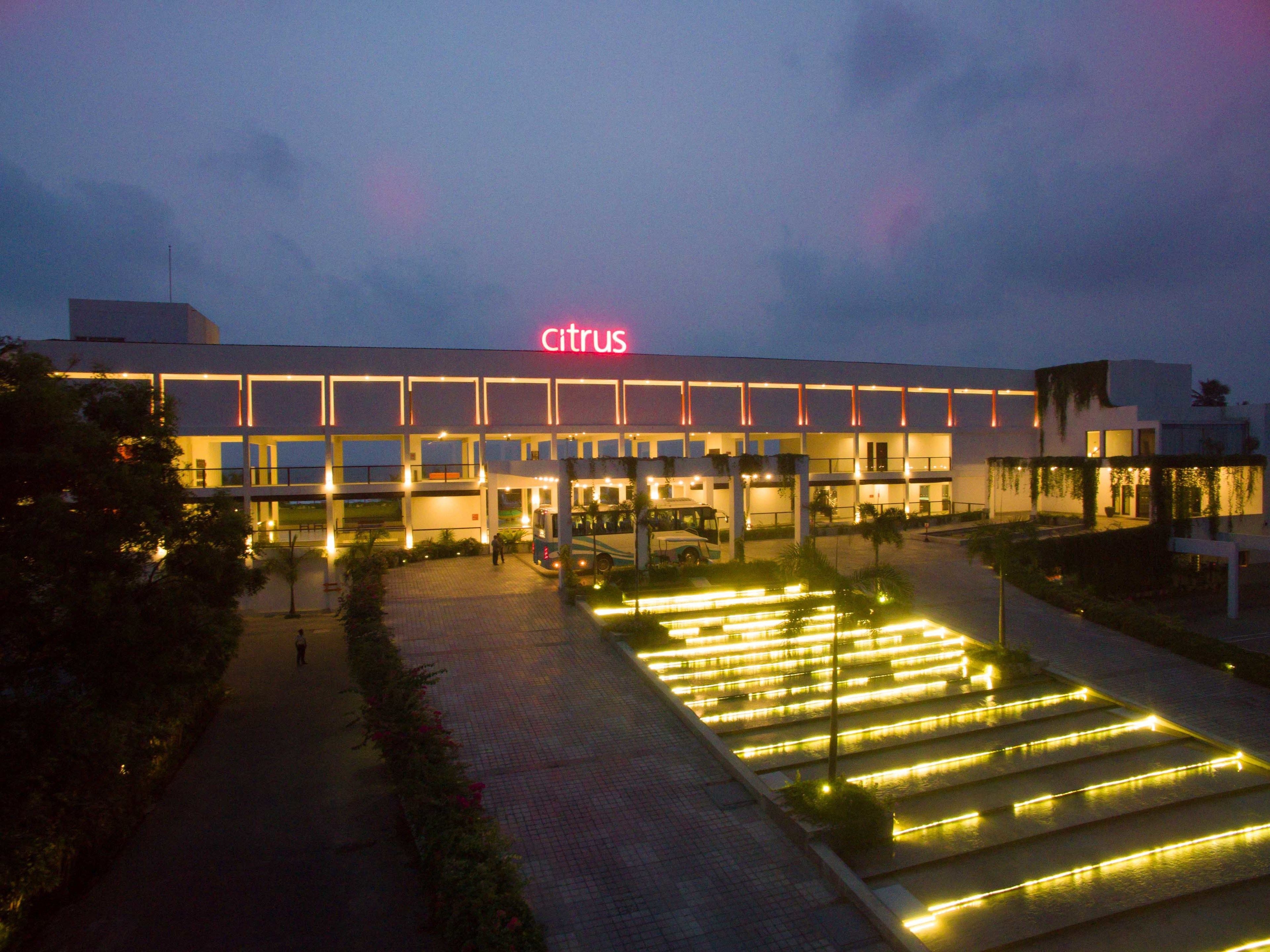 Un bâtiment moderne, orné d’une enseigne aux couleurs « agrumes », doté d’un hall d’entrée spacieux, d’un chemin éclairé et d’un jardin aménagé.