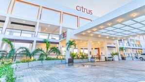 A modern building with the word "Citrus" on the facade, featuring a spacious entrance, multiple floors, and outdoor seating areas with plants. - Citrus Waskaduwa (Wadduwa)
