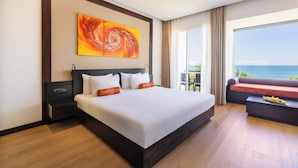A hotel room with a large bed, a view of the ocean, a sofa, and a dining table. - Citrus Waskaduwa (Wadduwa)
