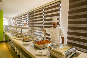 A buffet setup with multiple food stations, each with covered serving dishes and a variety of dishes visible. - Citrus Waskaduwa (Wadduwa)