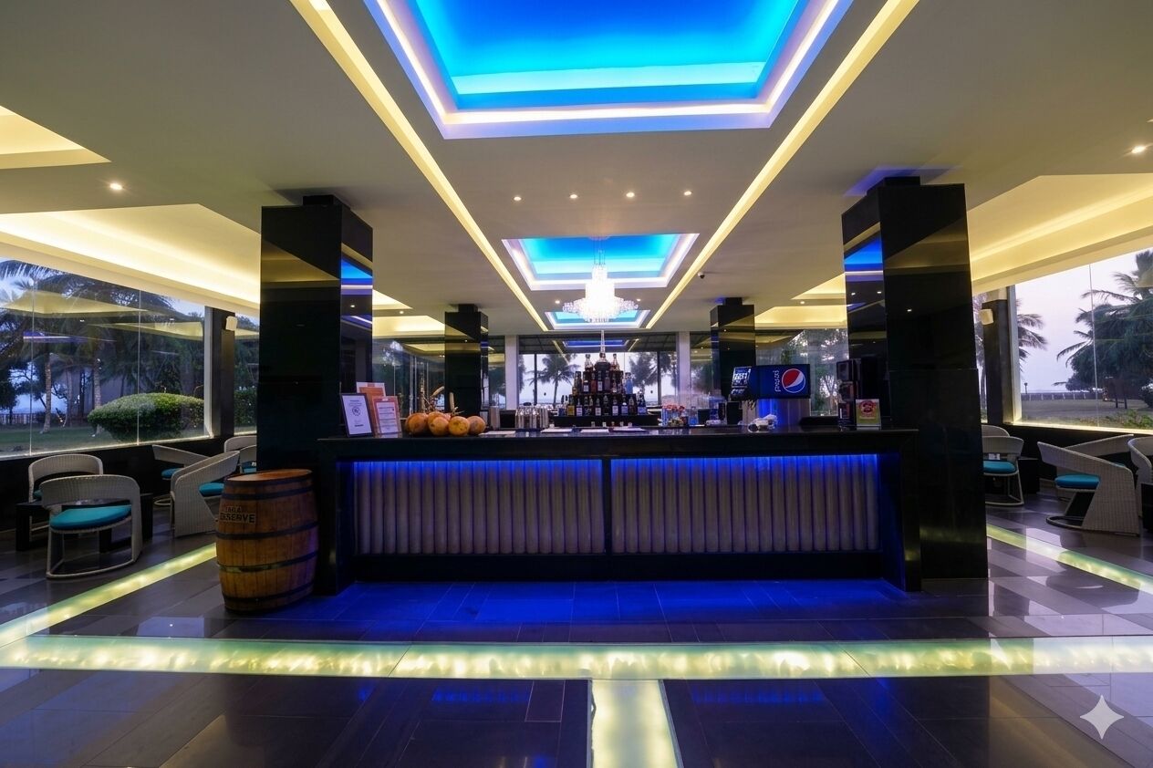 A bar area with a counter, seating, and a view of palm trees outside.