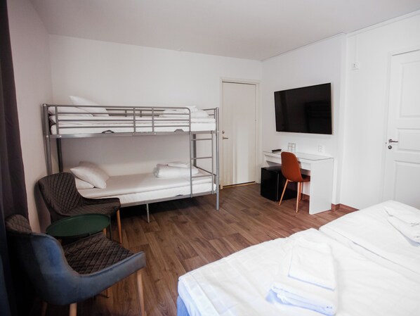 A hotel room with bunk beds, a desk, a chair, a television, and a bed. - NoKey Hotel Gävle (Gävle)