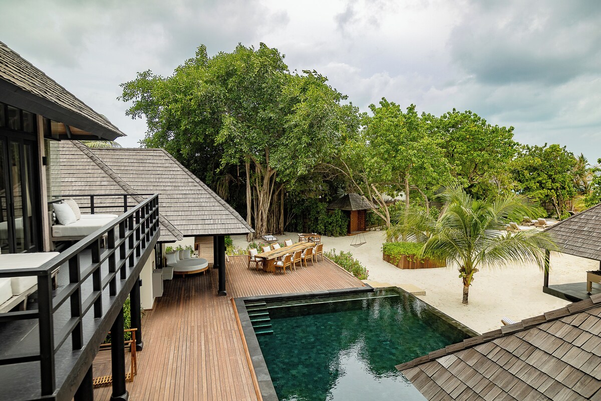 A resort with a pool, outdoor seating, and a deck area.