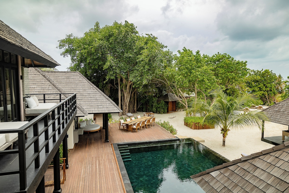 A resort with a pool, outdoor seating, and a deck area.