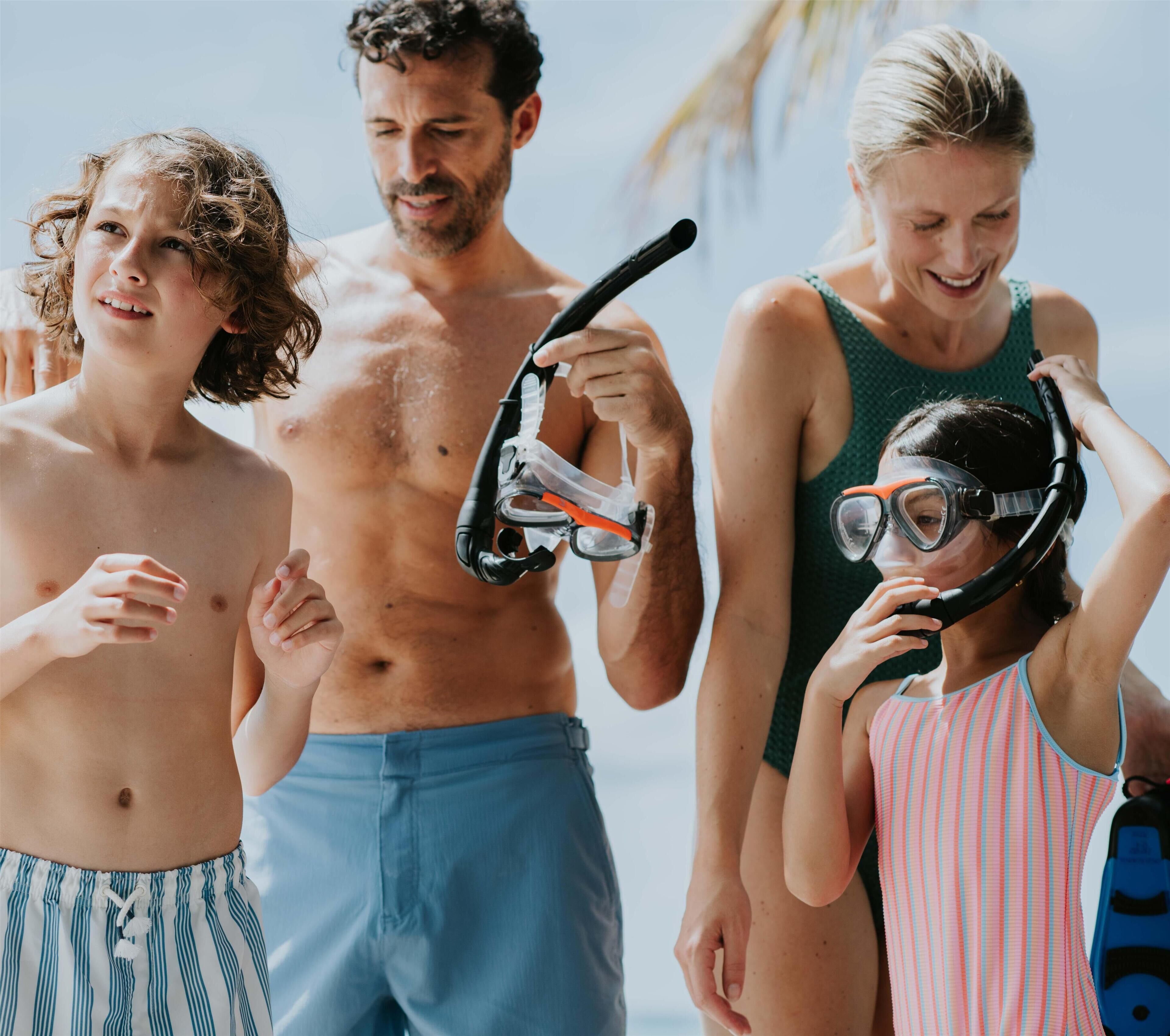 Un grupo de personas sosteniendo equipo de snorkel, sugiriendo un entorno de playa o actividad acuática.
