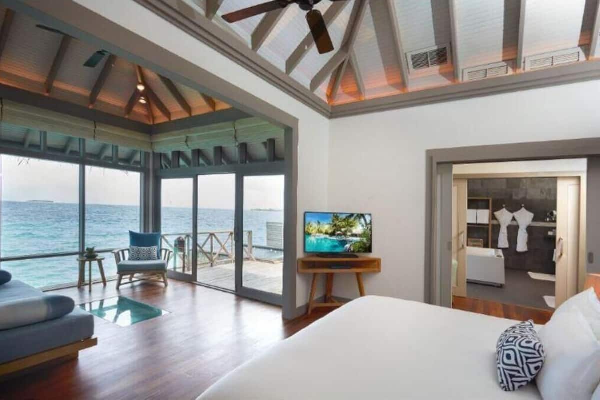 Ein Schlafzimmer mit einem großen Bett, einem Fernseher und Meerblick.