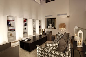 A modern living room with a sofa, a coffee table, and a bookshelf.