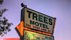 Un panneau indiquant un motel proposant des équipements tels que des chambres propres, une télévision à écran plat, une connexion Wi-Fi gratuite et la télévision par câble.