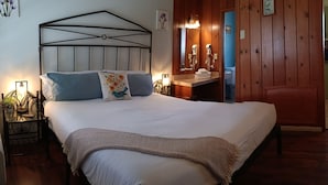 Une chambre à coucher avec un lit, des tables de chevet, un miroir et un mur en bois.