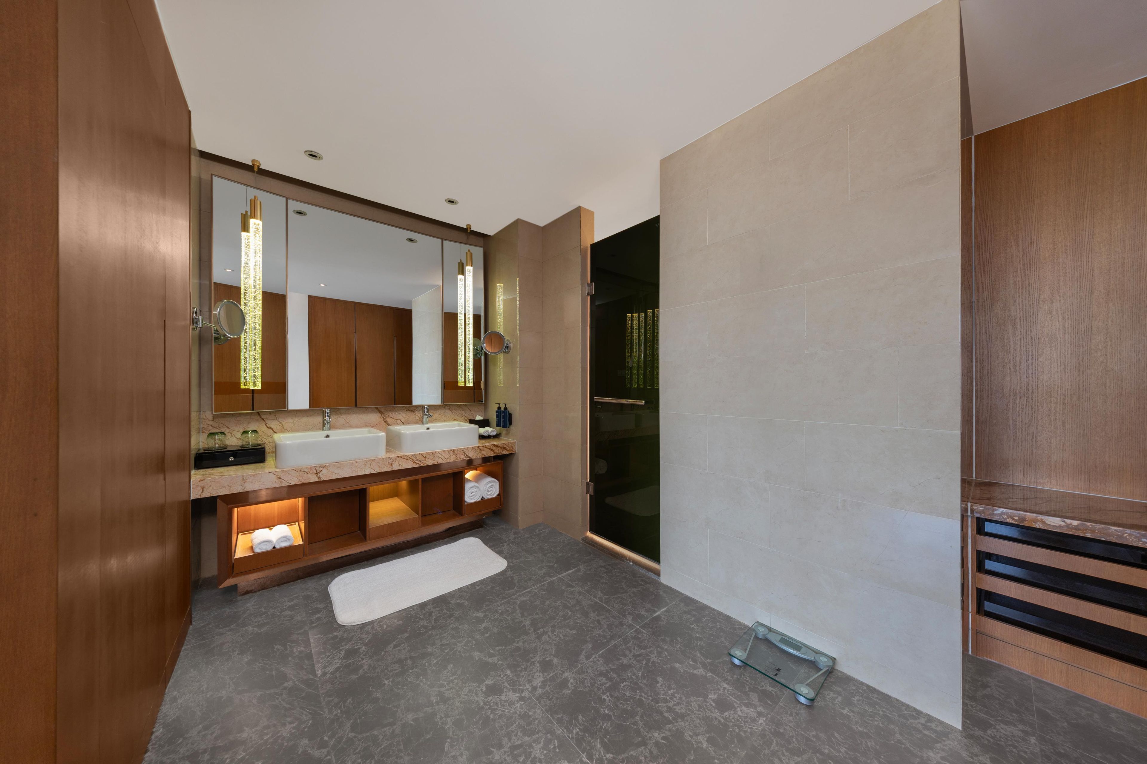 Une salle de bain moderne avec un meuble-lavabo à deux vasques, un grand miroir et une cabine de douche en verre.