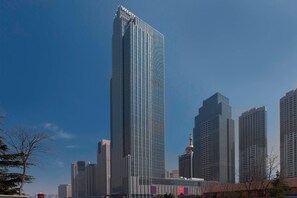 Un gratte-ciel moderne et imposant, doté d’une façade en verre et d’une partie supérieure au design distinctif.