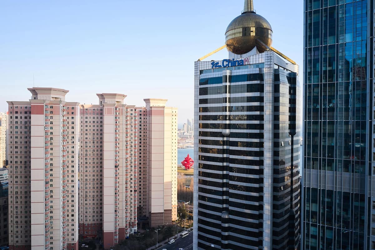 Un immeuble de grande hauteur, doté d’un sommet sphérique original et d’une enseigne indiquant « P.C. China ».