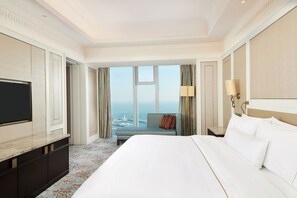 Une chambre d’hôtel avec un grand lit, une télévision, une vue sur la ville et une fenêtre avec des rideaux.