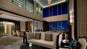 A spacious hotel lobby with a high ceiling, a large sofa, a coffee table, and a desk area. - The Westin Qingdao (Qingdao)