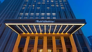 A hotel entrance with a modern facade, large glass windows, and a prominent sign. - The Westin Qingdao (Qingdao)