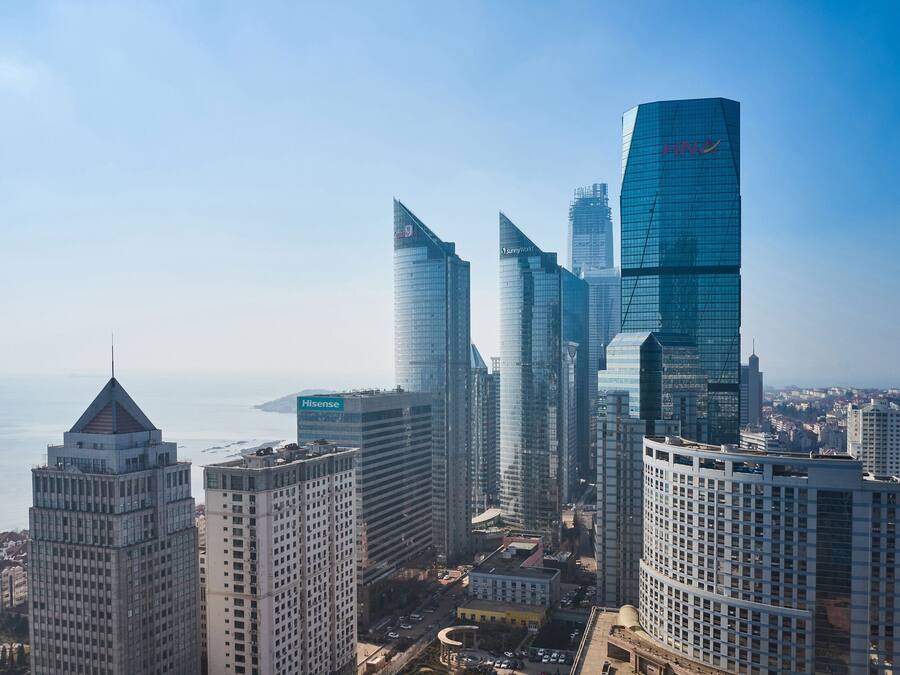 A high-rise urban skyline with modern architecture, including a prominent HN Tower and a building with a unique curved top.