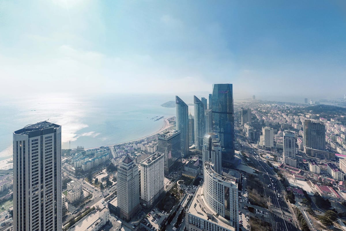 Un quartier urbain caractérisé par de nombreux immeubles de grande hauteur, des gratte-ciel modernes, un littoral et un paysage urbain dense.