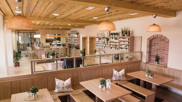 Un restaurant avec des bancs, des tables et des lampes suspendues, le tout en bois.