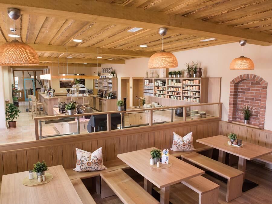 Un restaurant avec des bancs, des tables et des lampes suspendues, le tout en bois.