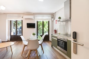 A modern kitchen with a built-in oven, a stainless steel range hood, and a wall-mounted digital lock.
