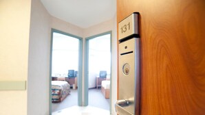 Entrada a una habitación de hotel con una puerta marcada “131” y vista al interior.