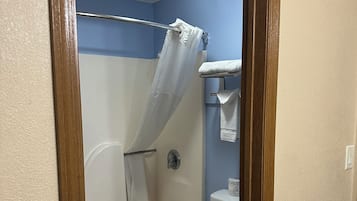 Une salle de bain avec une baignoire, des toilettes et un rideau de douche.