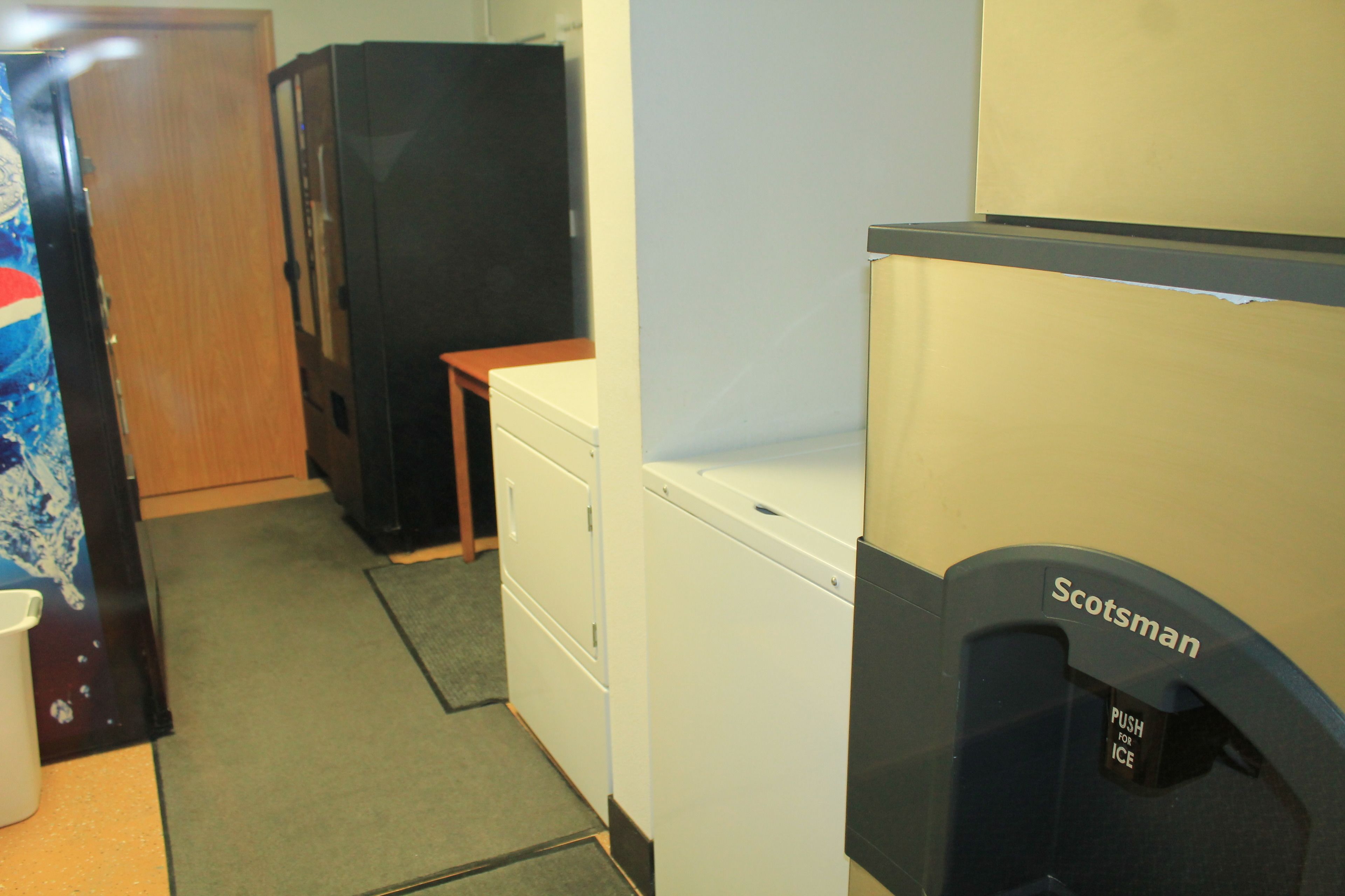A compact kitchen with a refrigerator, a microwave, and a small countertop.