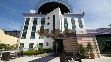 Experience the unique architecture of Castagni Hotel, featuring a central atrium and outdoor seating area.