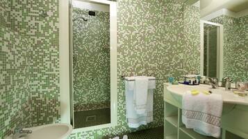 Un baño con lavamanos, espejo y ducha.