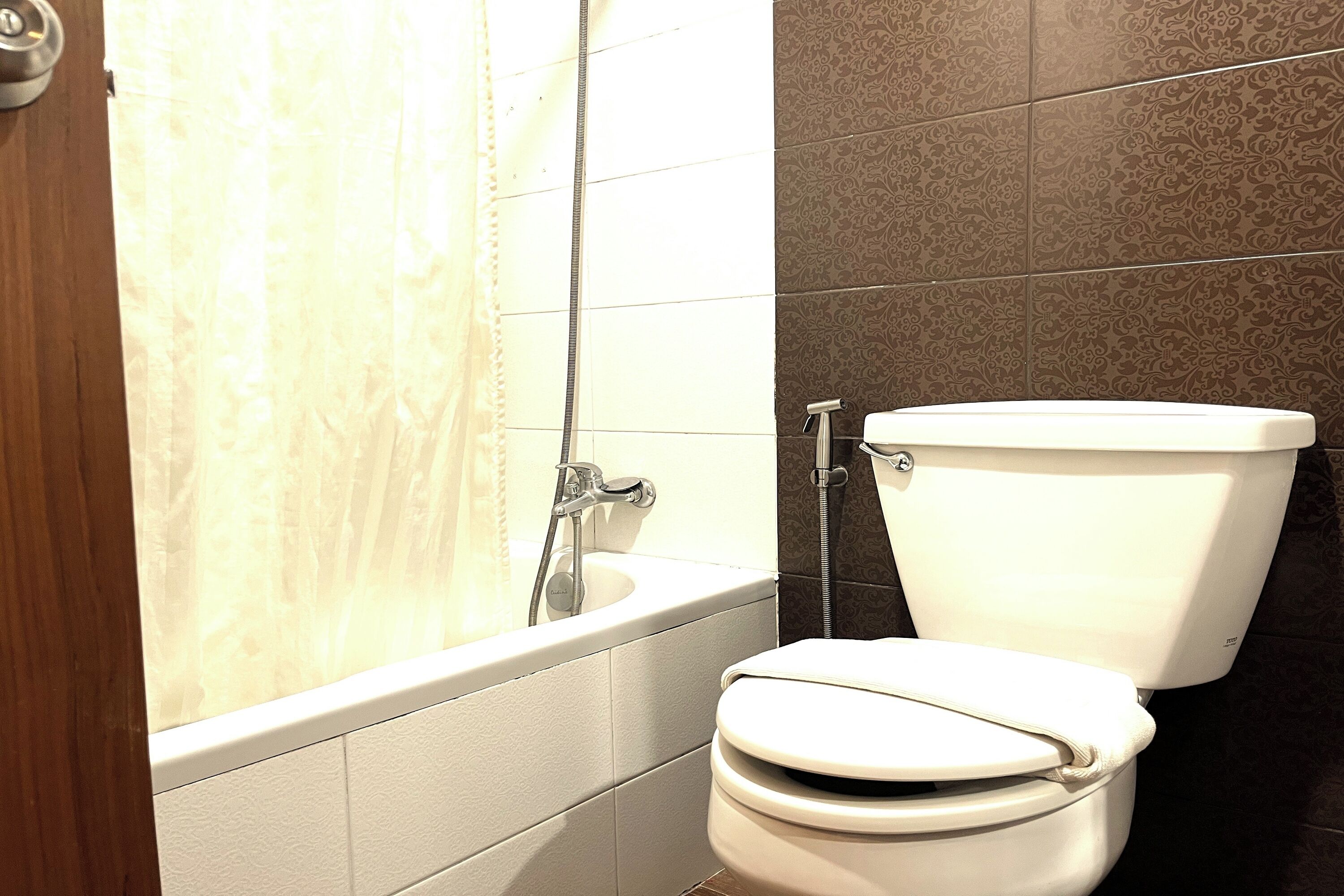 Un baño con bañera, inodoro y cabezal de ducha.