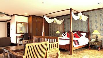 Ein Bett mit Himmelbett, ein Holztisch, ein Stuhl und ein Nachttisch mit Lampe.
