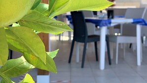 Un espacio al aire libre techado con una mesa y sillas, ideal para comer o reuniones.