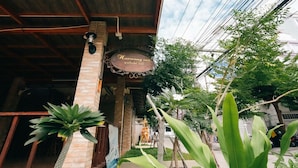 A building with a sign that reads 'Harmony Inn' and a covered entrance. - Harmony Inn (Pattaya)