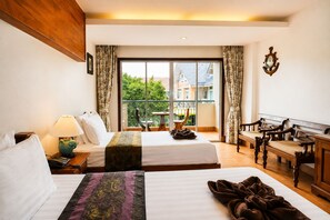 Une chambre d’hôtel avec deux lits, un bureau, une chaise, une lampe et une vue sur l’extérieur.