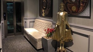 A modern room with a white tufted sofa, a decorative golden statue, and two large circular wall art pieces. - Access inn Pattaya (Pattaya)
