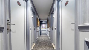 A hallway with doors on both sides, a patterned carpet, and a framed picture on the wall. - Access inn Pattaya (Pattaya)