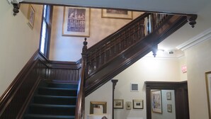 A grand staircase with dark wood railings and a handrail, leading to an upper floor. - Madison Manor Boutique Hotel (Toronto)
